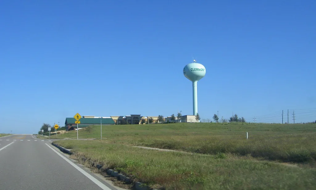 A water tower bearing the Clermont name beside a city highway.