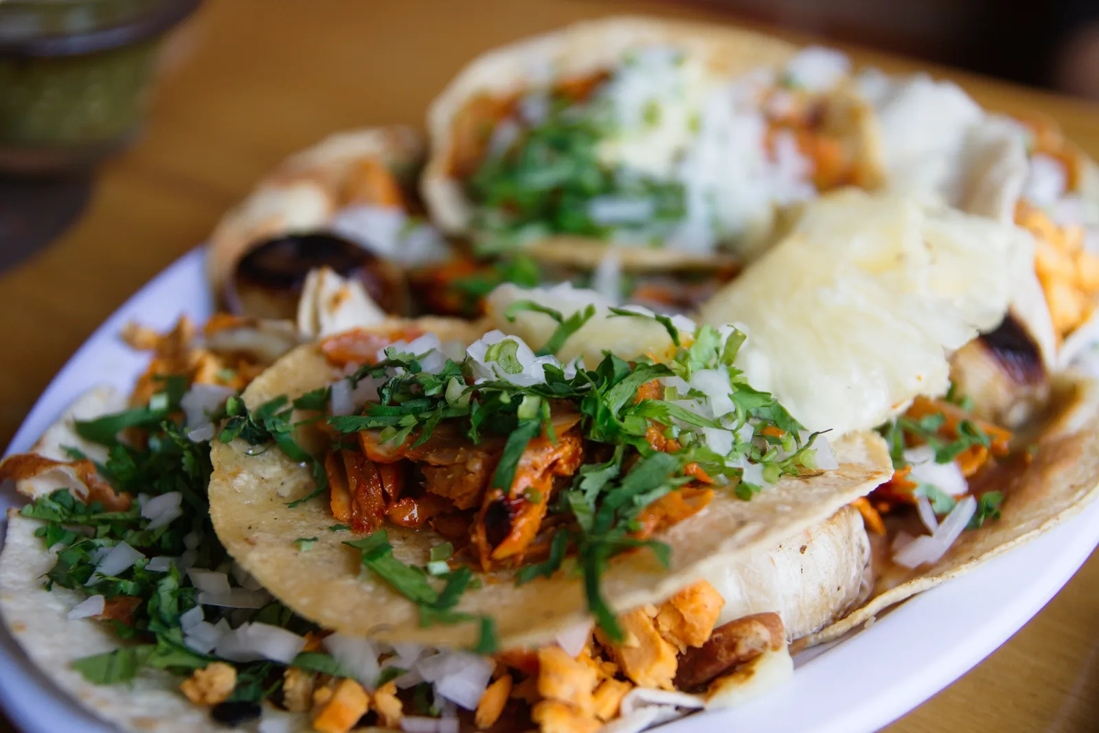 A plate of tacos al pastor topped with onion and cilantro. The photo was not taken at a Clermont restaurant.